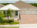 A gorgeous home's exterior featuring a covered porch, three-car garage, paved driveway, and manicured lawn at 14711 Winter Stay Dr, Winter Garden, FL 34787