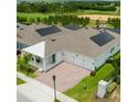 A beautiful home's exterior featuring solar panels, a brick paved driveway, a covered entryway, and a manicured lawn at 14711 Winter Stay Dr, Winter Garden, FL 34787