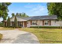 Charming home with whitewashed brick, custom wood shutters, and a manicured lawn for a cozy curb appeal at 201 Cedarwood Dr, Maitland, FL 32751