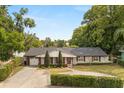 Attractive one-story home with a circular driveway, trimmed hedges and a two-car garage at 201 Cedarwood Dr, Maitland, FL 32751