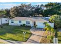 Charming yellow single-story home with a well-manicured lawn, mature trees, and a convenient attached garage at 2070 Keyes Ln, Deltona, FL 32738