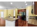 Modern kitchen featuring cherry wood cabinets, granite countertops, stainless steel appliances, and hardwood floors at 2081 The Oaks Blvd, Kissimmee, FL 34746