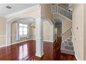 Elegant living room featuring gleaming hardwood floors, decorative columns, and a staircase to the second floor at 2081 The Oaks Blvd, Kissimmee, FL 34746