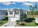 Charming two-story home featuring a two-car garage, well-manicured lawn, and lush landscaping at 216 Miles Ct, Davenport, FL 33837