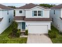 Charming two-story home featuring a two-car garage and a welcoming light-blue front door at 2237 Wood Stork Ln, St Cloud, FL 34771