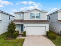 Charming two-story home featuring a two-car garage and a welcoming light-blue front door at 2237 Wood Stork Ln, St Cloud, FL 34771