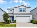 Charming two-story home featuring a two-car garage and a welcoming light-blue front door at 2237 Wood Stork Ln, St Cloud, FL 34771