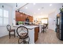 Bright kitchen with wood cabinets, stainless steel appliances, breakfast bar, and views into the adjacent dining area at 2289 Aloe Aly, Apopka, FL 32703