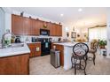 Well-equipped kitchen with wood cabinets, stainless steel appliances, and a breakfast bar overlooking the dining area at 2289 Aloe Aly, Apopka, FL 32703