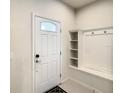 Bright entryway with white door, coat rack, and tile floor adding a modern touch and functionality to the space at 2412 Tanger Dr, Kissimmee, FL 34747