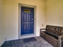 Elegant blue front door with glass panels, covered porch, and bench providing a secure and stylish entrance at 2412 Tanger Dr, Kissimmee, FL 34747