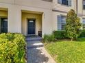 Inviting covered entry with a blue front door, neat landscaping, and a tiled walkway for a welcoming approach at 2412 Tanger Dr, Kissimmee, FL 34747