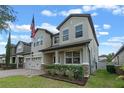 Inviting home featuring a manicured lawn, a charming front porch, and a two-car garage at 5144 Ravena E Ave, St Cloud, FL 34771