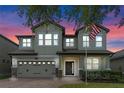 Charming two-story home featuring a brick driveway and a well-manicured lawn against a vibrant sunset backdrop at 5144 Ravena E Ave, St Cloud, FL 34771