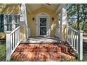 Inviting front porch with classic brick steps and decorative pillars at 519 N Clara Ave, Deland, FL 32720