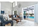 Bright living room with tile floors, leather sofas, and a view of the pool at 5502 Willow Bend Trl, Kissimmee, FL 34758