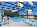 Inviting screened-in pool area with stylish lounge furniture and a picturesque lake view at 5502 Willow Bend Trl, Kissimmee, FL 34758