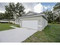 Side view of home with a large garage and extended driveway at 6038 Sw 154Th Place Rd, Ocala, FL 34473