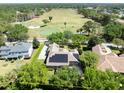 Aerial view of property with solar panels, screened in pool, and golf course community at 6110 Keenes Pointe Dr, Windermere, FL 34786