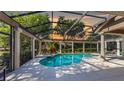 Screened-in pool with hot tub, stone columns, and outdoor seating providing a relaxing backyard oasis at 6110 Keenes Pointe Dr, Windermere, FL 34786