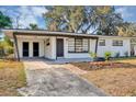 Charming single-story home featuring a covered carport and freshly landscaped front yard with flowers at 6312 Appian Way, Orlando, FL 32807