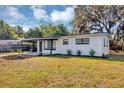 Charming single-story home featuring a covered carport and freshly landscaped front yard with flowers at 6312 Appian Way, Orlando, FL 32807