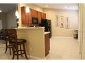 Eat-in kitchen features cherry cabinets, black appliances, tile backsplash and unique wall decor at 6453 Alcalde Ct # 104, Orlando, FL 32835