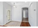 Bright foyer with tile flooring, featuring a decorative glass front door and arched entryway at 819 Featherstone Ln, Lake Mary, FL 32746