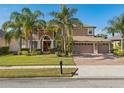 Charming two-story home with lush landscaping, brick paved driveway, and a three-car garage at 920 Nola Dr, Ocoee, FL 34761