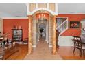 Grand foyer with decorative columns and archway, complemented by hardwood floors and terracotta-colored walls at 920 Nola Dr, Ocoee, FL 34761