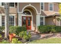 Elegant arched entryway with double doors and manicured landscaping at 920 Nola Dr, Ocoee, FL 34761