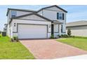 Beautiful two-story home featuring a brick driveway, attached garage and manicured front lawn at 4532 Windy Oak Way, St Cloud, FL 34772