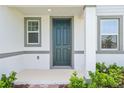 Close up of the front entrance showing the front door, sidelight windows and trimmed shrubs at 4532 Windy Oak Way, St Cloud, FL 34772