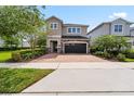 Charming two-story home featuring a brick driveway, a two-car garage, and beautiful landscaping at 7392 Marker Ave, Kissimmee, FL 34747