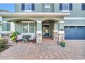 Inviting front porch with stone accents, seating area, and a beautiful entryway door at 7503 Marker Ave, Kissimmee, FL 34747