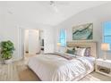 Bright bedroom features a large bed with soft linens, a walk-in closet, and light wood floors at 840 Cortez Ave, The Villages, FL 32159