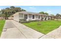 A charming home with a well-kept lawn, inviting driveway, and beautiful stone facade in a lovely neighborhood at 1011 Terry Dr, Altamonte Springs, FL 32714