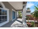 Home's entrance featuring a covered porch, decorative columns, and a blue front door at 1028 Marietta Ln, Eustis, FL 32726