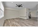 Bright living room with light-colored walls, wood floors, a ceiling fan, and large windows at 1037 Sailing Bay Dr, Clermont, FL 34711