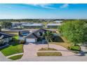 Expansive aerial view of home with pool, brick paved circular driveway, and mature landscaping at 104 Bentley Oaks Blvd, Auburndale, FL 33823