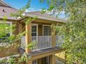 A cozy, covered balcony featuring white railings and a view framed by lush foliage, enhancing the outdoor living experience at 10852 Spider Lily Dr # S, Orlando, FL 32832