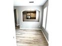 Open concept living space featuring modern wood flooring and arched entry into kitchen at 10852 Spider Lily Dr # S, Orlando, FL 32832
