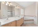 Bathroom featuring double sinks, a soaking tub, and a glass-enclosed shower at 1330 Broken Pine Rd, Deltona, FL 32725