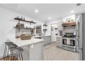 Stylish kitchen featuring an island with breakfast bar, stainless steel appliances, and herringbone flooring at 1558 Regal Oak Dr, Kissimmee, FL 34744