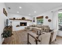 Bright living room with a white brick fireplace, mantle, and new wood flooring at 1558 Regal Oak Dr, Kissimmee, FL 34744