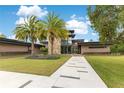 A modern home with stone accents, a lush green lawn, and a contemporary walkway at 1766 Alaqua Dr, Longwood, FL 32779