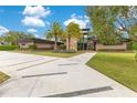 A modern home with stone accents, a lush green lawn, and a contemporary walkway at 1766 Alaqua Dr, Longwood, FL 32779