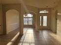 Bright foyer with tile flooring, high ceilings, arches and a decorative front door with glass panels at 2715 Bartlet Dr, Kissimmee, FL 34741