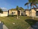 Inviting single-Gathering home featuring a well-kept lawn and a three car garage, complemented by a mature palm tree at 2715 Bartlet Dr, Kissimmee, FL 34741