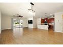 Bright, open-concept living room with wood-look tile flooring flowing into the kitchen area at 3053 Brook Stone Ter, Davenport, FL 33837